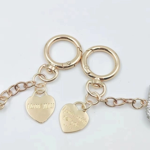 Detailed view of golden metal heart charms engraved with romantic text on a keychain