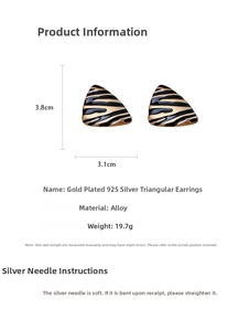 Detail view of gold-plated zebra stripe triangle earrings with 925 silver needles
