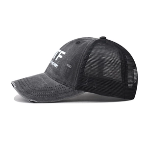 Close-up of vintage washed black trucker hat with TF white print and mesh back