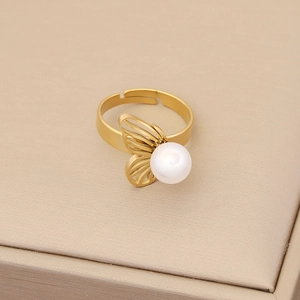 Macro shot of an adjustable gold butterfly ring featuring a polished white pearl inlay