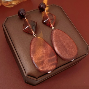 Detailed close-up of retro resin drop earrings with wood grain texture on jewelry box