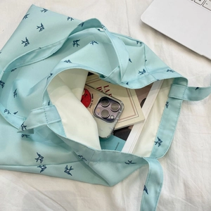 Close-up of light blue canvas tote bag with bird prints and large internal capacity