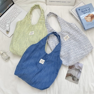 Mise à plat de sacs cabas en toile à carreaux bleu et jaune avec accessoires
