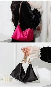 Detailed view of satin tote bag with gold chain strap in rose red and black colors
