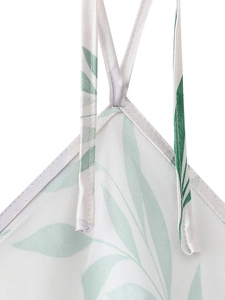 Détail des fines bretelles et du tissu en satin floral sur la robe dos nu blanche