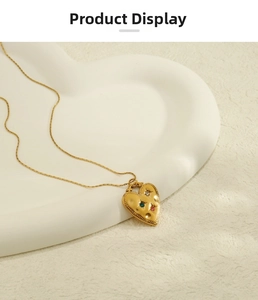 Détail du collier cœur doré avec texture martelée et pierres de zircon colorées