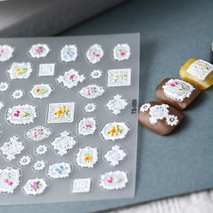 Detail of 3D embossed white lace nail stickers with colorful floral patterns TS-059
