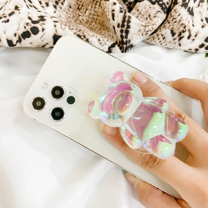 Close-up of 3D laser bear phone grip with iridescent gradient on white smartphone