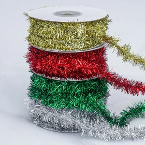 Close-up of metallic Christmas tinsel garlands in gold, red, green and silver rolls