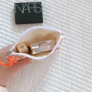 Floral cotton mini storage pouch showing interior space for lipstick and powder compact