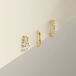 Detailed set of gold earrings with marquise cubic zirconia studs and a sleek ear cuff