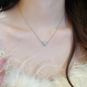 Collier triangle argenté élégant avec pavé de zircons sur le cou d'un mannequin