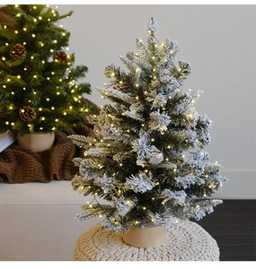 Mini snowy Christmas tree detail with warm LED lights, pine cones and wooden base