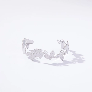 Detailed view of silver open cuff bracelet featuring continuous matte butterfly design
