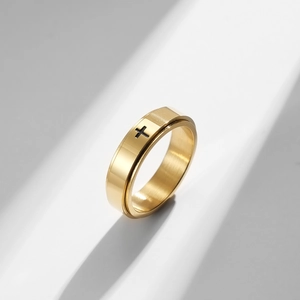Close-up of golden stainless steel spinner ring with a black cross and brushed finish