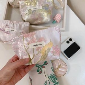 Close-up of floral jacquard mini storage bag with woven bird pattern and gold thread