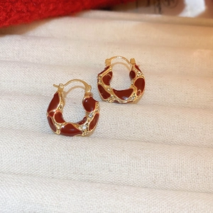 Close-up of vintage red enamel hoop earrings with gold plating and cubic zirconia