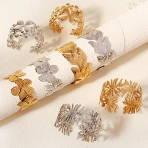 Detailed macro view of golden and silver metallic leaf and flower napkin rings or bracelets