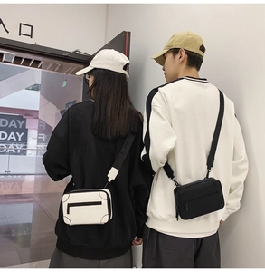 Detail of minimalist box crossbody bags in black and white with wide nylon straps