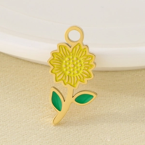 Macro shot of a gold stainless steel sunflower pendant with yellow and green enamel finish