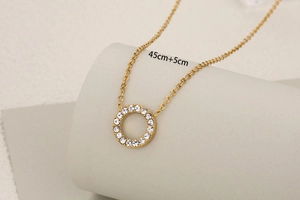 Detailed view of gold necklace with round diamond pendant and 45+5cm size annotation