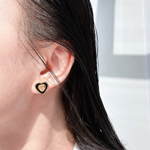 Vintage gold heart studs with black enamel finish worn for an elegant side view