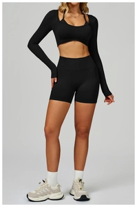 Detailed view of black seamless long-sleeve crop top and high-waist fitness shorts