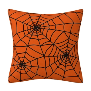Close-up of orange linen pillow cover featuring a black spider web pattern for Halloween