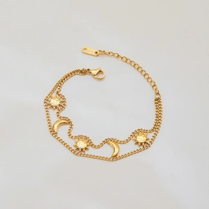 Golden stainless steel bracelet with sun and moon pendants on a white background