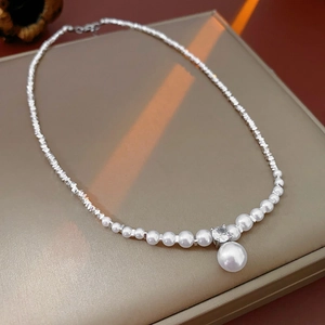 Macro shot of faux pearl necklace with large pearl drop pendant and sparkling zircon stone