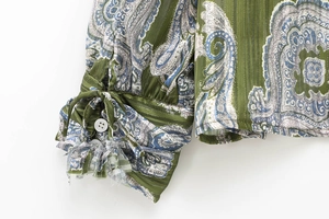 Detail of green paisley shirt sleeve featuring drawstring cuffs and delicate stitching