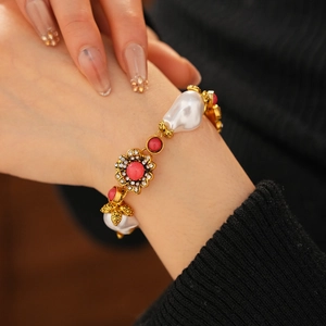 Close-up of vintage gold bracelet with white pearls and pink beads on a model's wrist