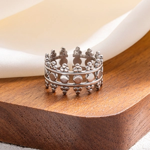 Detailed shot of retro crown silver ring with embossed texture on white silk background