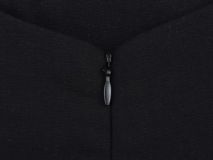 Dettaglio della cerniera invisibile su tessuto nero di un mini abito minimalista