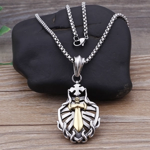 Detail view of hip-hop silver shield pendant with gold sword on black stone base