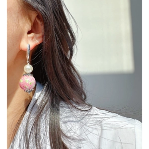 Chic silver earring with white pearl and pink-green glass bead on model