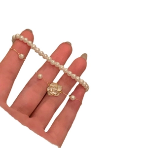 Elegante pulsera de perlas de doble capa con dije de camelia blanca y detalles dorados