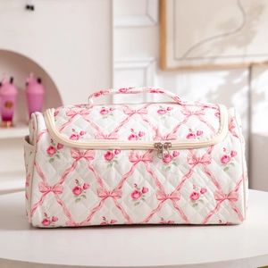 Detailed macro view of quilted toiletry bag with pink rose and bow floral prints