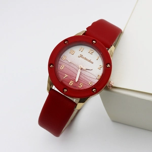 Detail of red leather strap and gradient watch dial with golden markers and studs