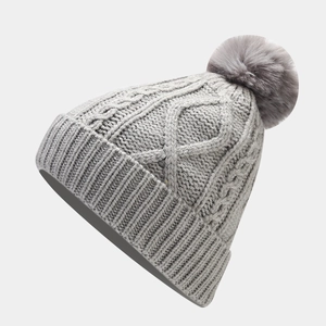 Detailed knit pattern of grey beanie with faux fur pom-pom and ribbed cuff detail