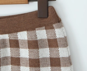 Detailed close-up of brown and white checkered knit fabric with textured pattern