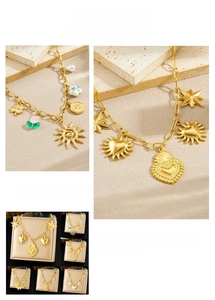 Detailed view of vintage gold-plated necklaces with sun and heart charms on natural stone