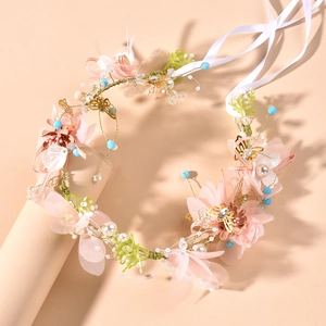 Close-up of floral bridal headband with silk flowers, white pearls and gold accents