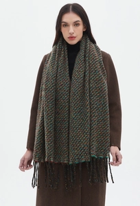 Detail of colorful knitted scarf with fringe tassels on heavy winter wool blend material
