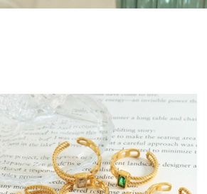 Detail of vintage gold adjustable rings featuring braided textures and emerald green gems