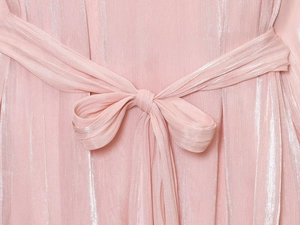 Détail de robe plissée rose avec ceinture élégante et tissu aux reflets métalliques