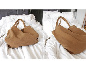 Dual view of brown canvas tote bag showing spacious interior on a white bed