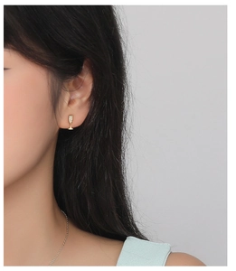 Macro shot of gold goblet earrings with micro-inlaid diamonds worn by a model