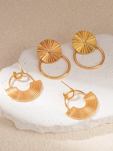 Detailed view of gold leaf-textured titanium earrings on a stone background