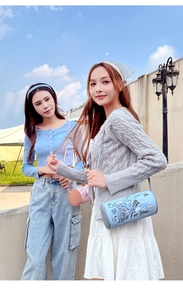 Close-up of a blue and pink PU leather cylinder crossbody bag with graffiti print